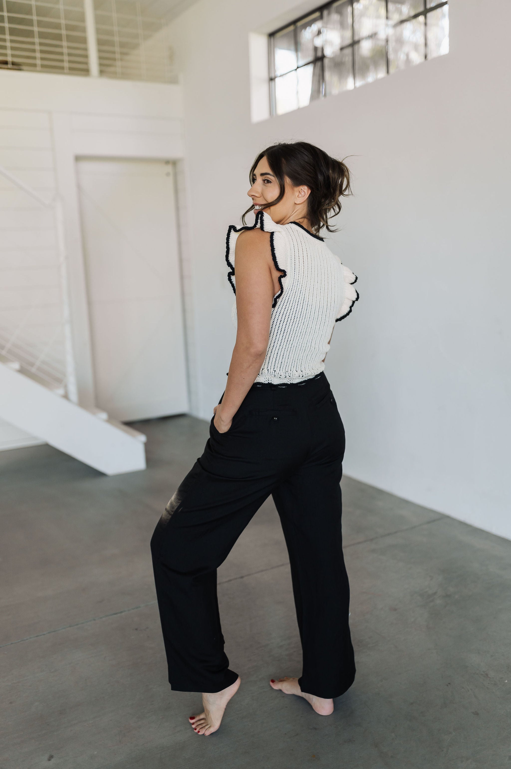 Rear angled view of Chloe Pleat Linen Pant in black with relaxed leg, side pocket, and rear trouser pockets. 