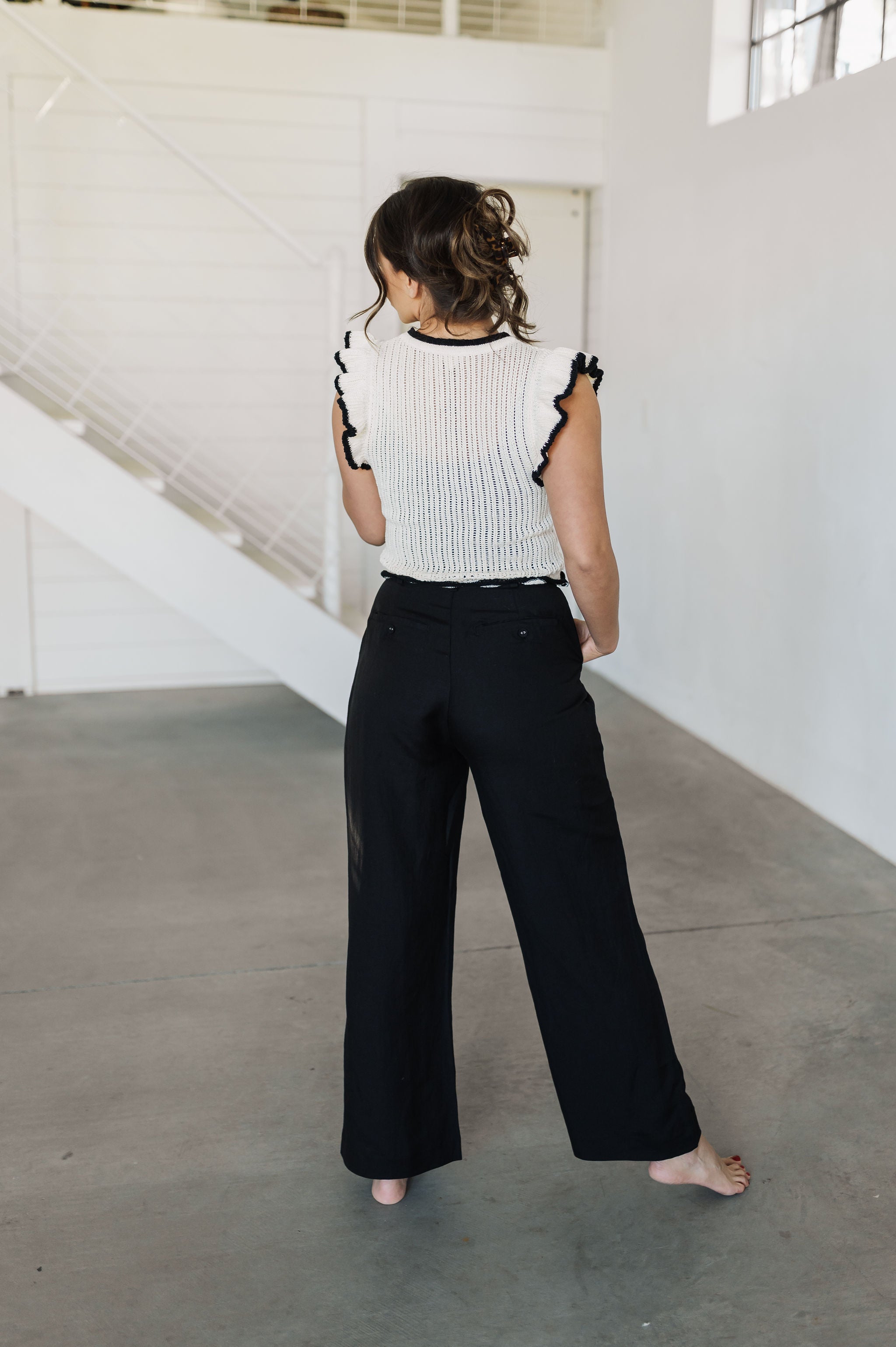 Rear view of Chloe Pleat Linen Pant in black with relaxed leg and trouser pockets. 