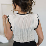 Rear view of pointelle knit Piper Knit Top with ruffled sleeves and hem and contrast piping detail.