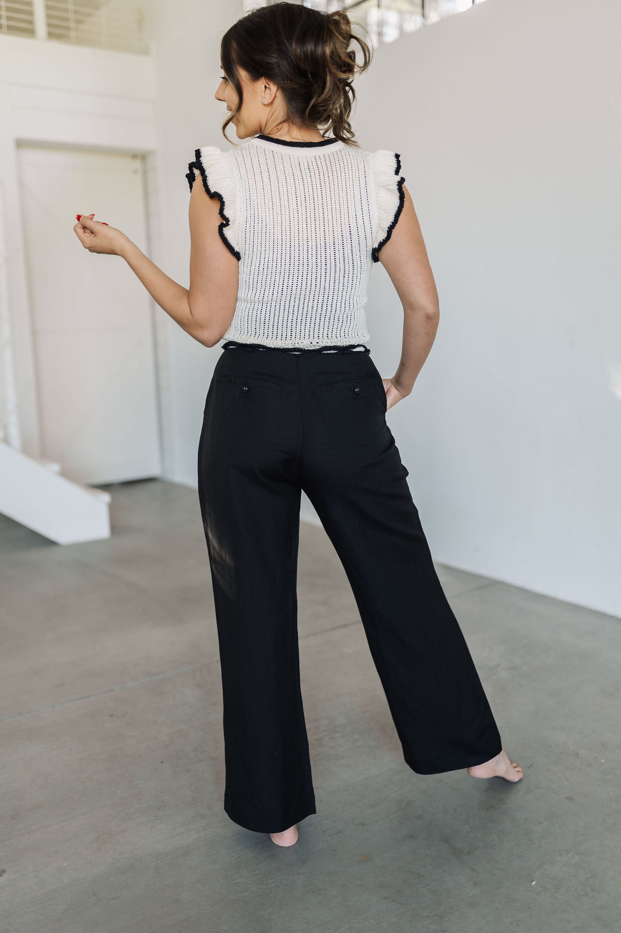 Rear view of Chloe Pleat Linen Pant in black with relaxed leg and trouser pockets.