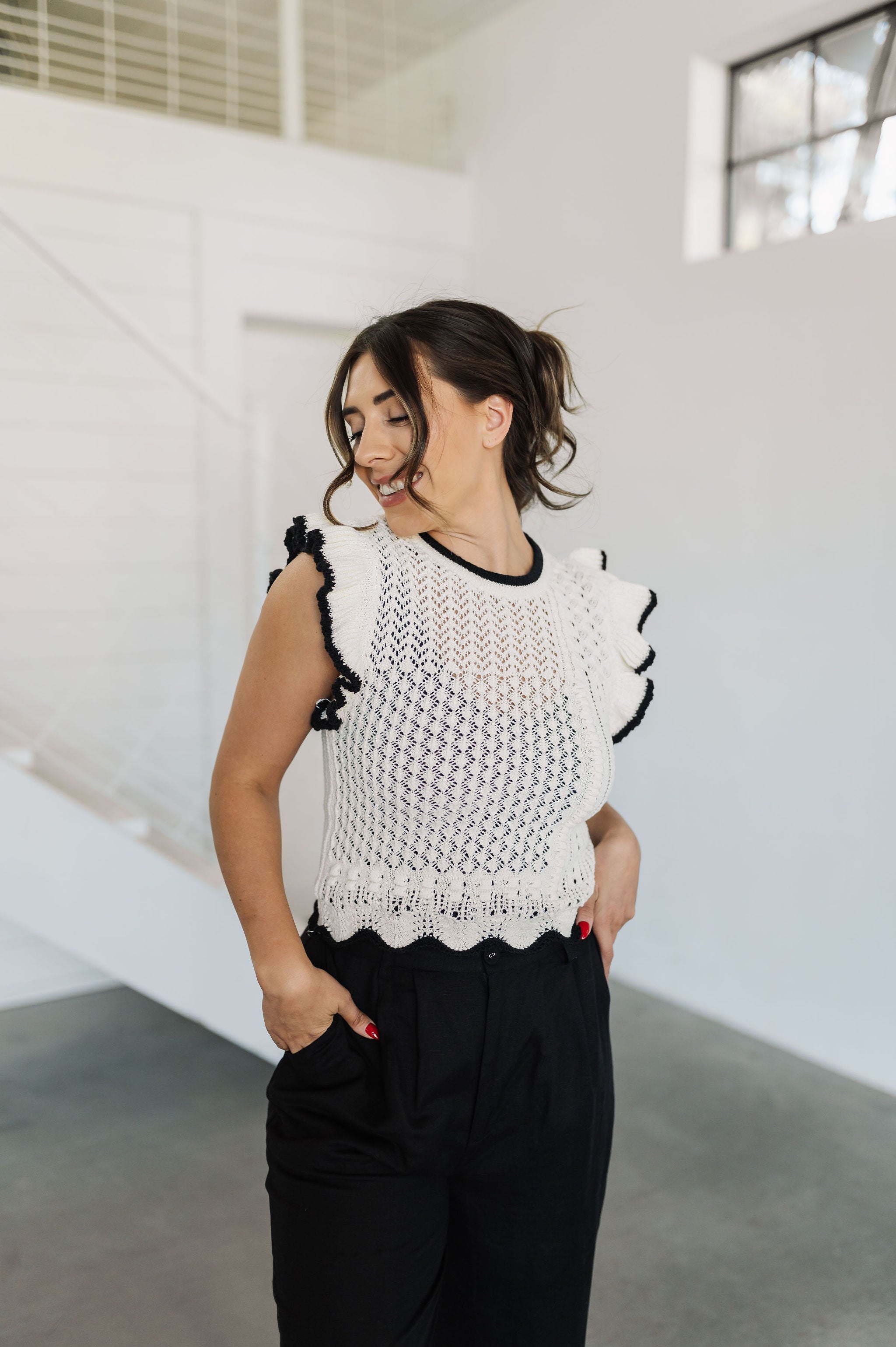 Front view of pointelle knit Piper Knit Top with ruffled sleeves and hem and contrast piping detail. 