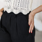Close up bottom view of pointelle knit Piper Knit Top with ruffled hem and contrast piping detail. 