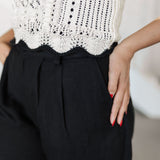 Close up bottom view of pointelle knit Piper Knit Top with ruffled hem and contrast piping detail. 