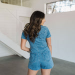 Rear view of Ranch Romper in blue with rear embroidered pockets.