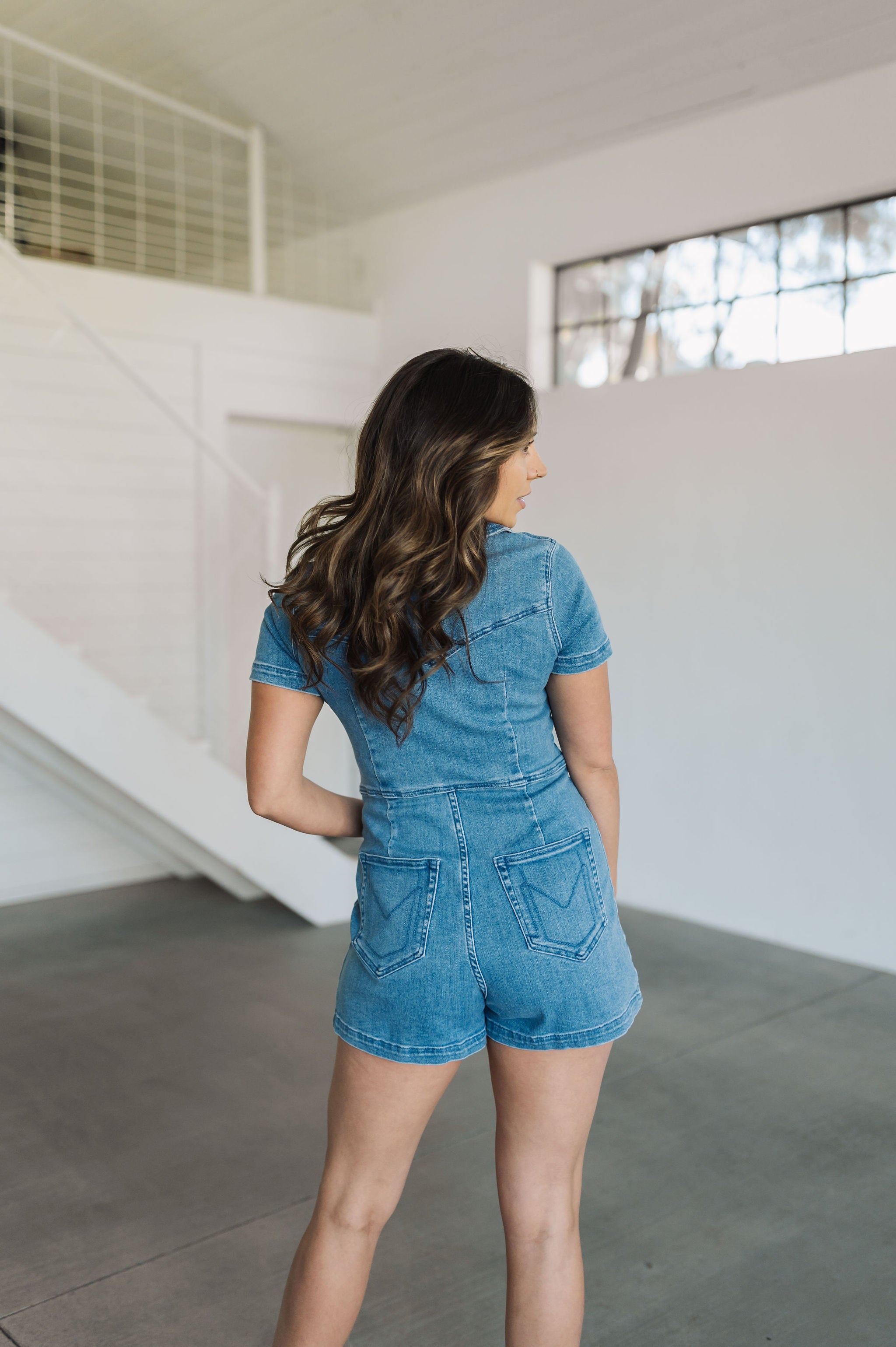 Rear view of Ranch Romper in blue with rear embroidered pockets.