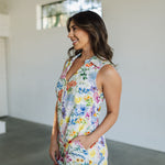 Side view of sleeveless Reno Romper in allover floral print, zip up front, collared neckline, and side pockets.