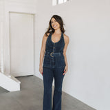 Front view of Fort Worth Jumpsuit in blue with button up front, belted waist, patch pockets, and flared leg. 