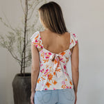 Rear view of Azalea Tie Back Tank Top with flutter straps, tie back closure, and neon floral print. 