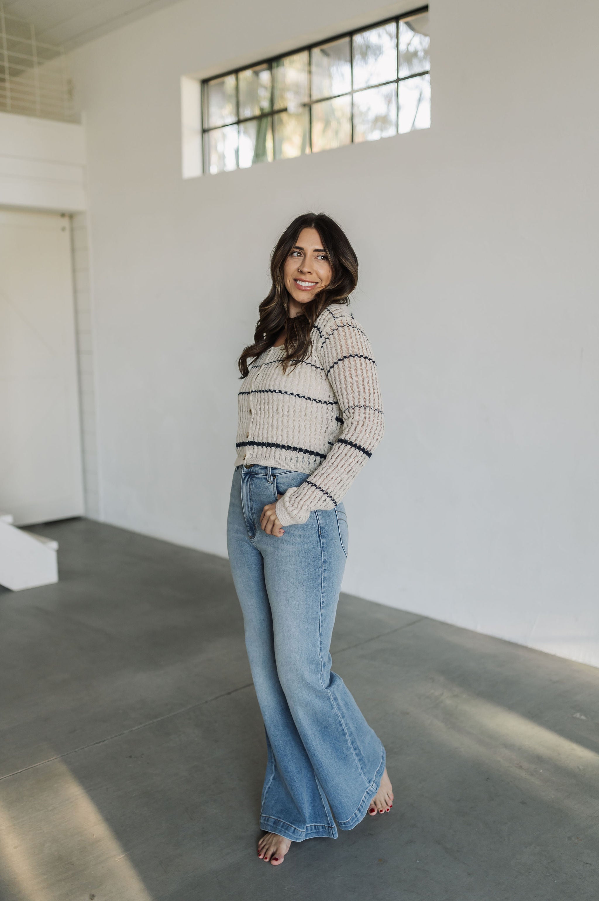 Side view of striped button up Hazel Cardigan with scoop neck.