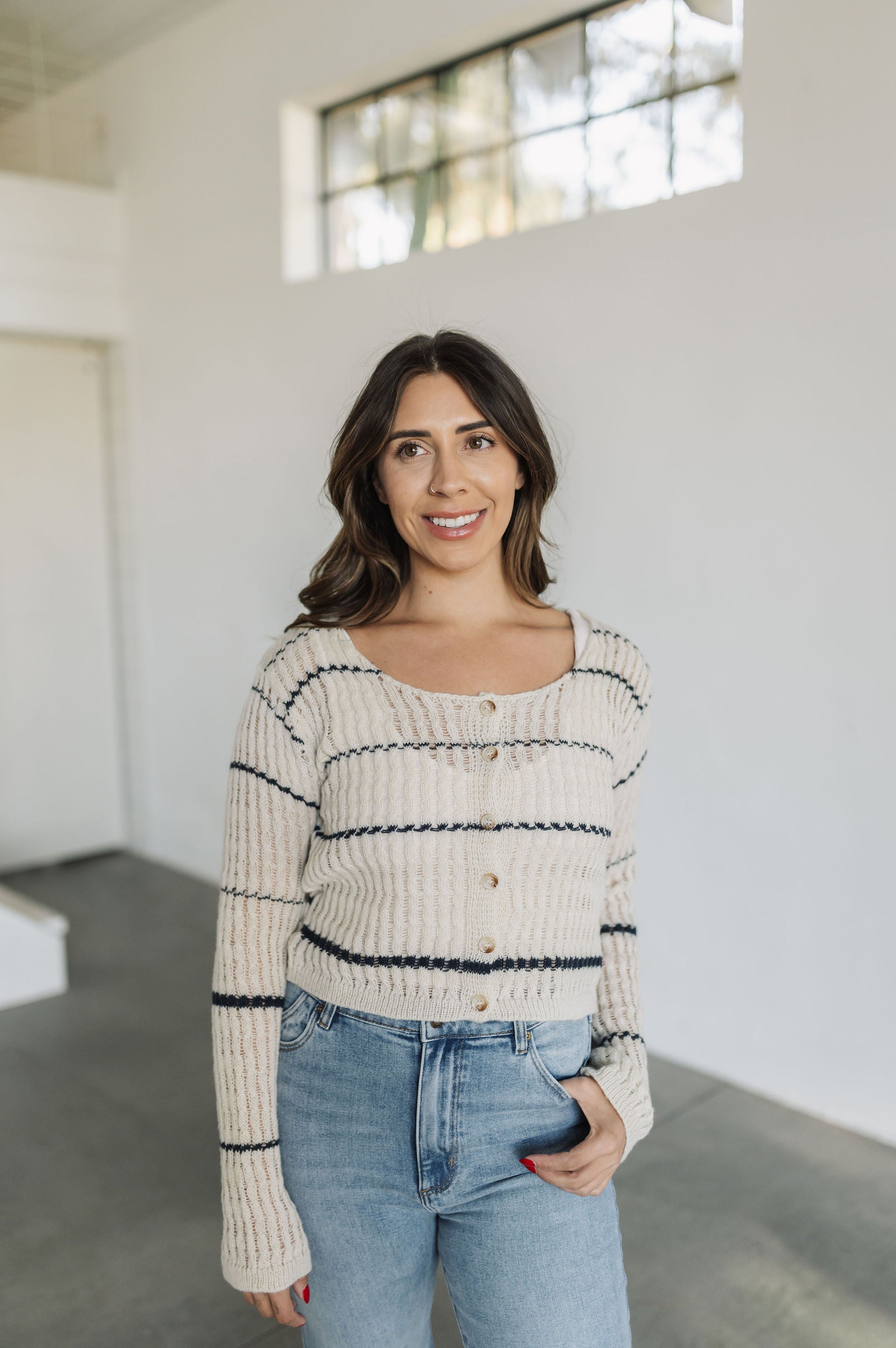 Front view of striped button up Hazel Cardigan with open stitching and scoop neck.