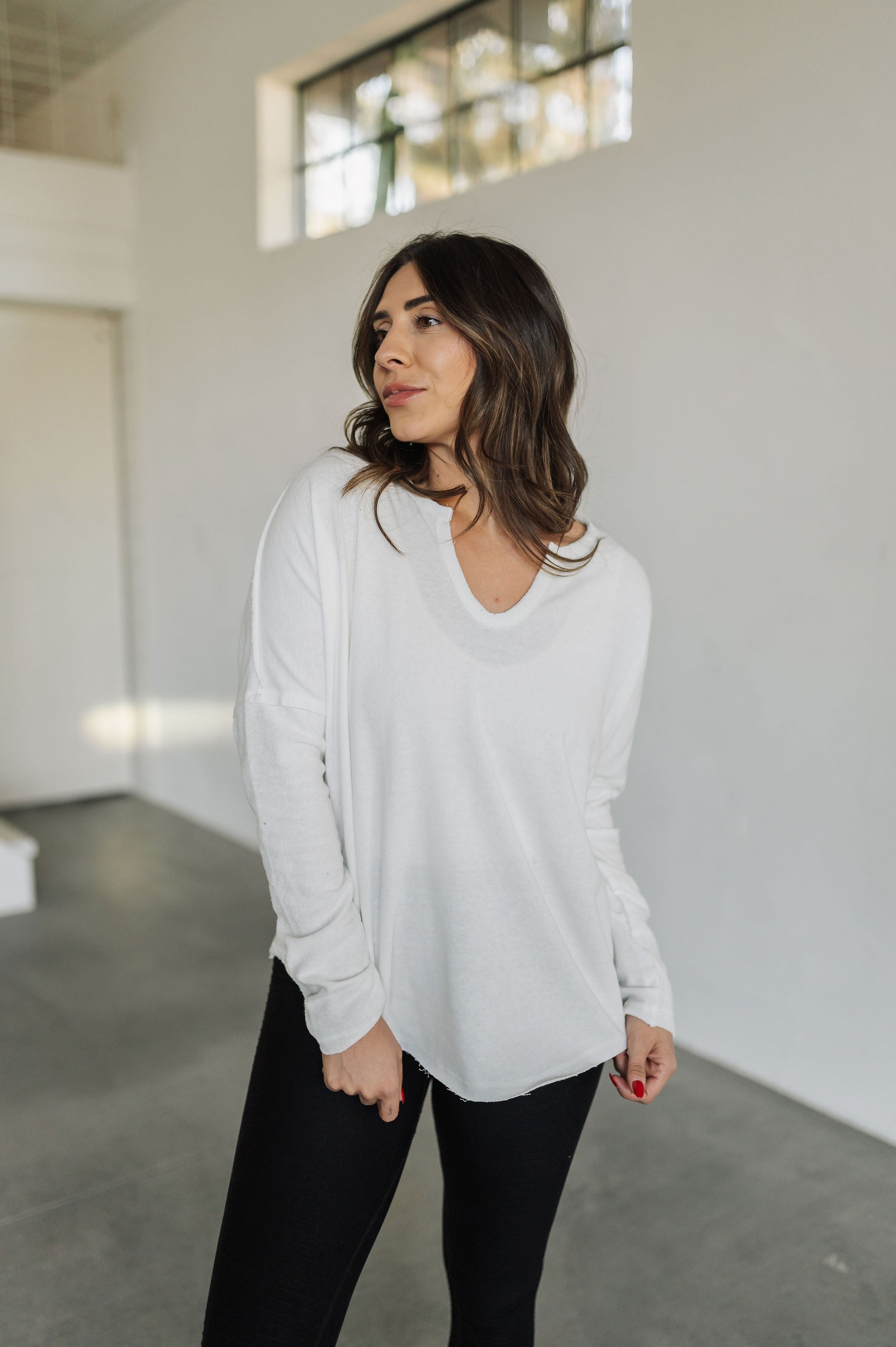 Front view of Harper Long Sleeve Top with notch neckline and raw hem. 