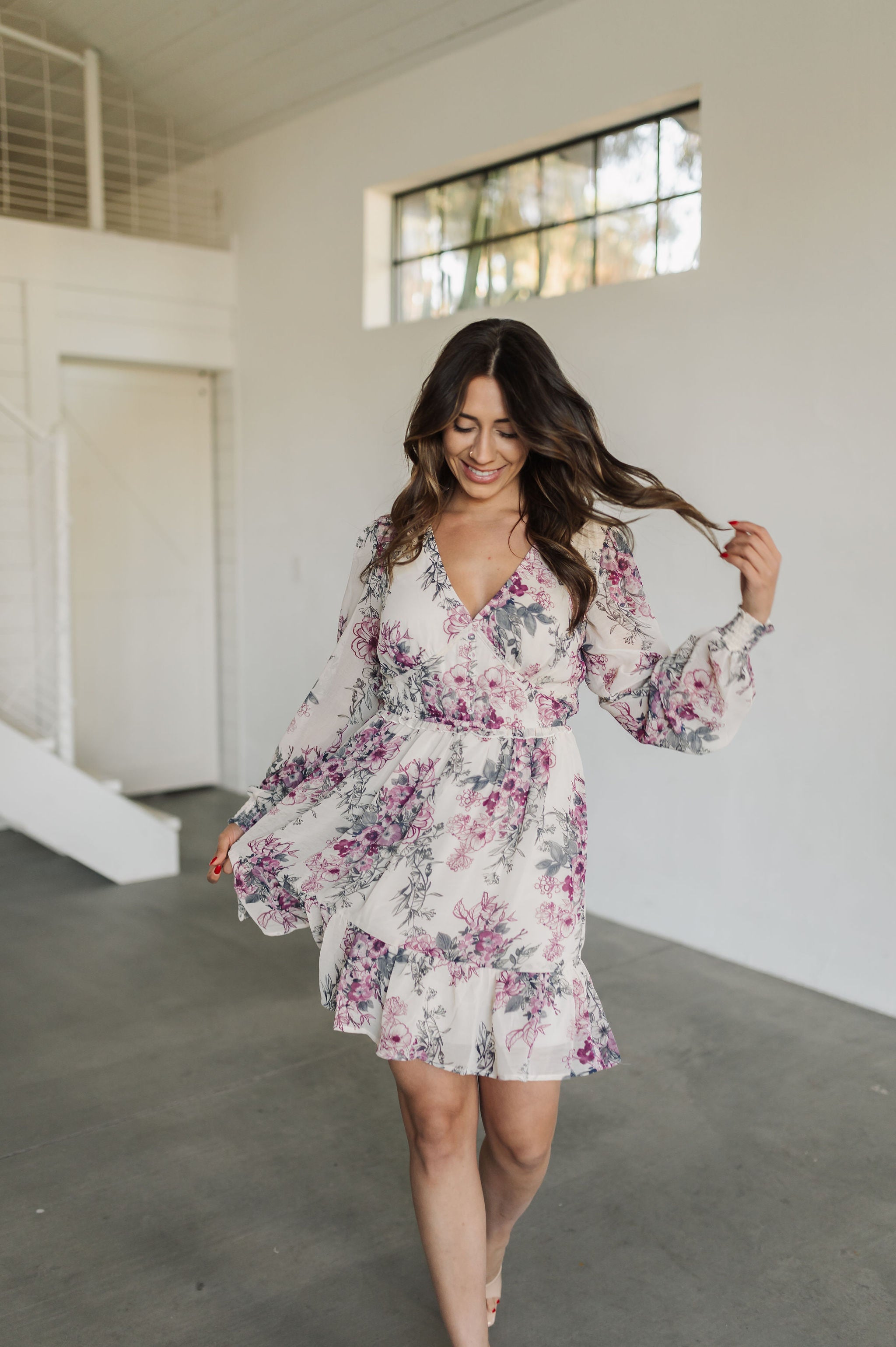 Front view of Aster Floral Mini Dress with V-neck, long sleeves, and ruffled hem. 