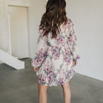 Rear view of Aster Floral Mini Dress with long sleeves and ruffled hem. 