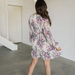 Rear view of Aster Floral Mini Dress with long sleeves and ruffled hem. 