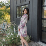 Side view of Aster Floral Mini Dress with long sleeves and ruffled hem. 