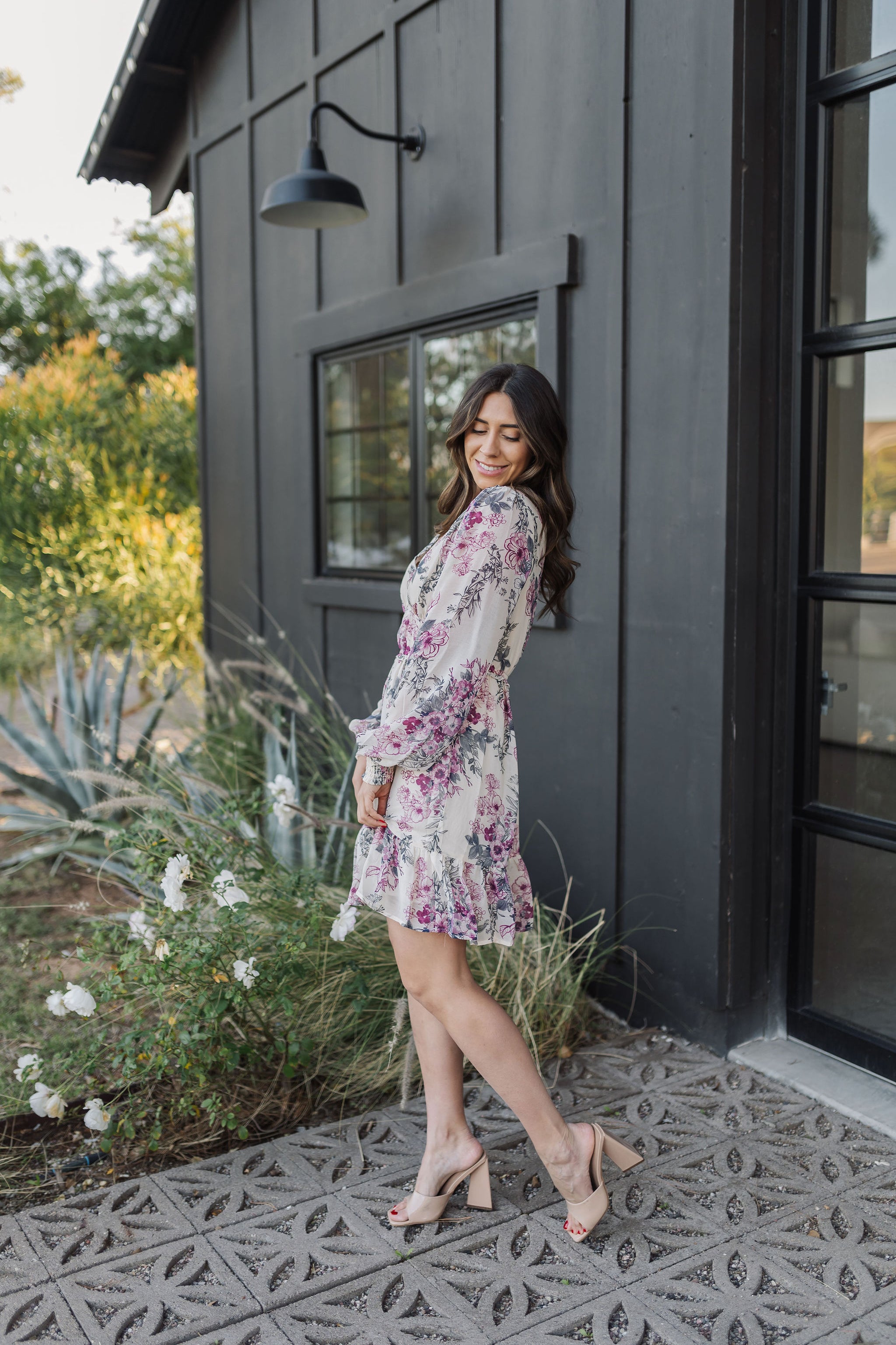 Side view of Aster Floral Mini Dress with long sleeves and ruffled hem. 