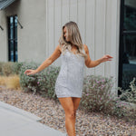 Front view of Sparks Fly Mini Dress with thin straps and allover fringe and sequin details. 