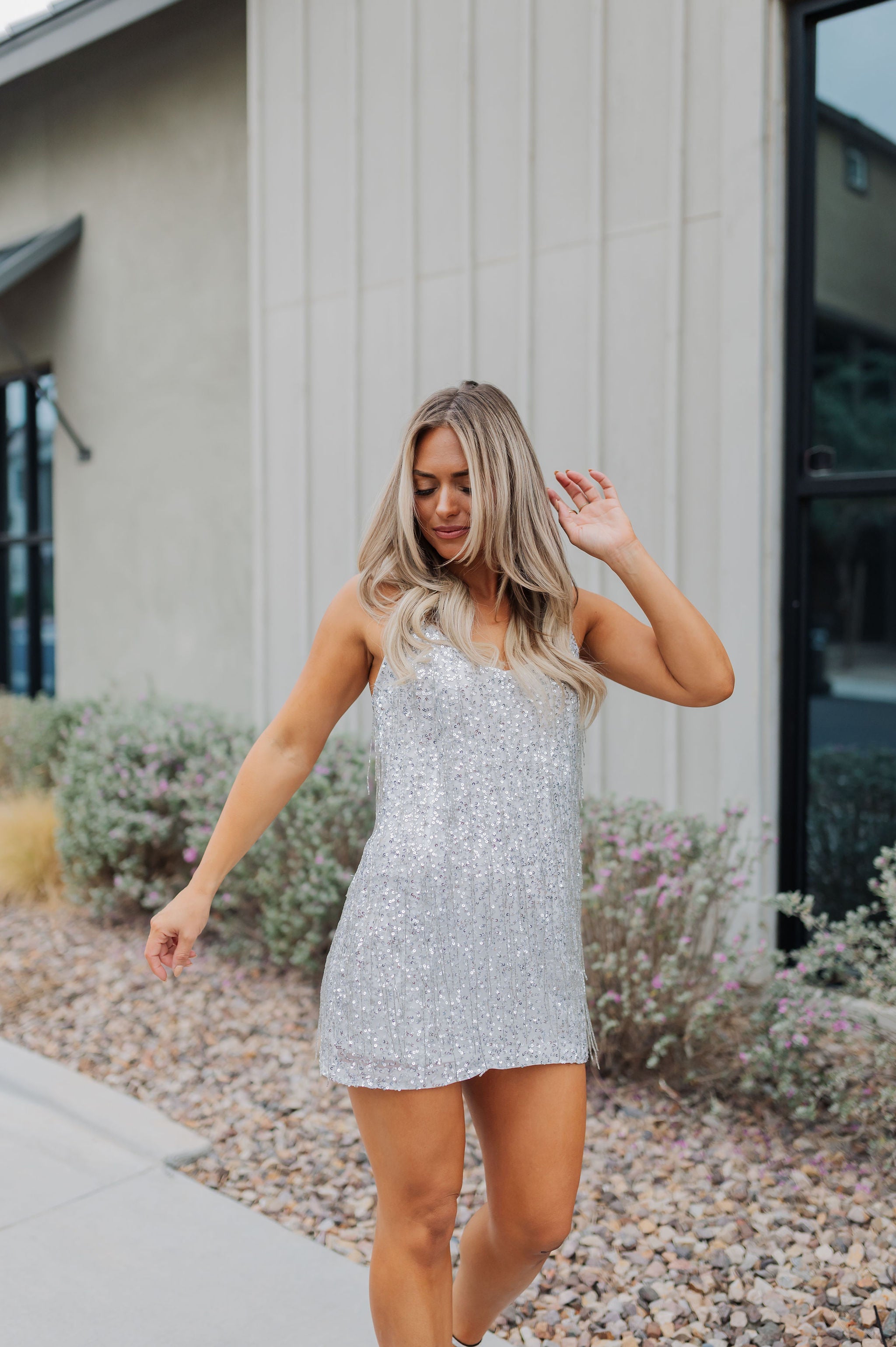 Front view of Sparks Fly Mini Dress with thin straps and allover fringe and sequin details. 