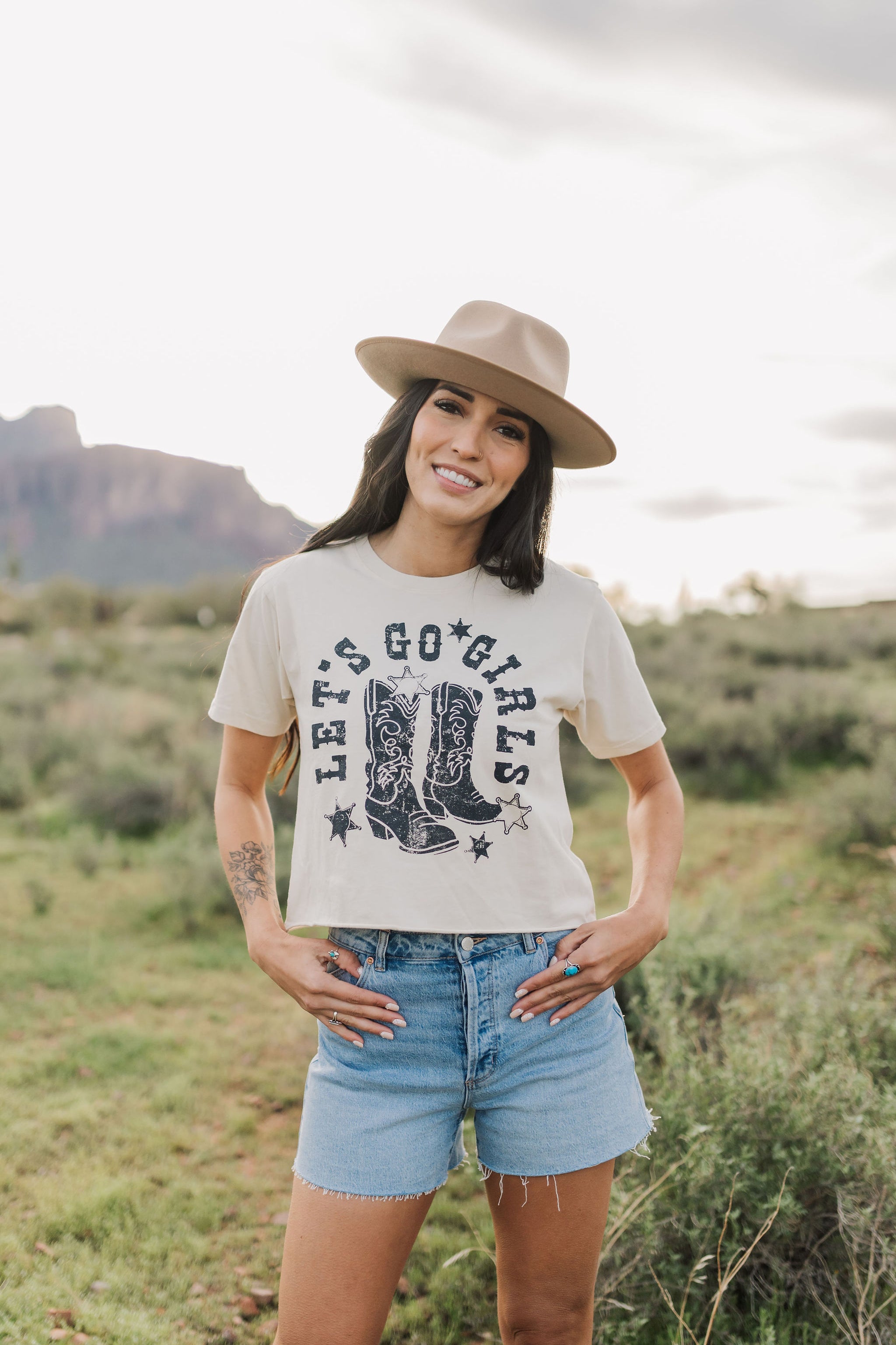 Front view of cropped Let's Go Girls Graphic Tee with a mineral wash, distressed graphic, and raw hem.  