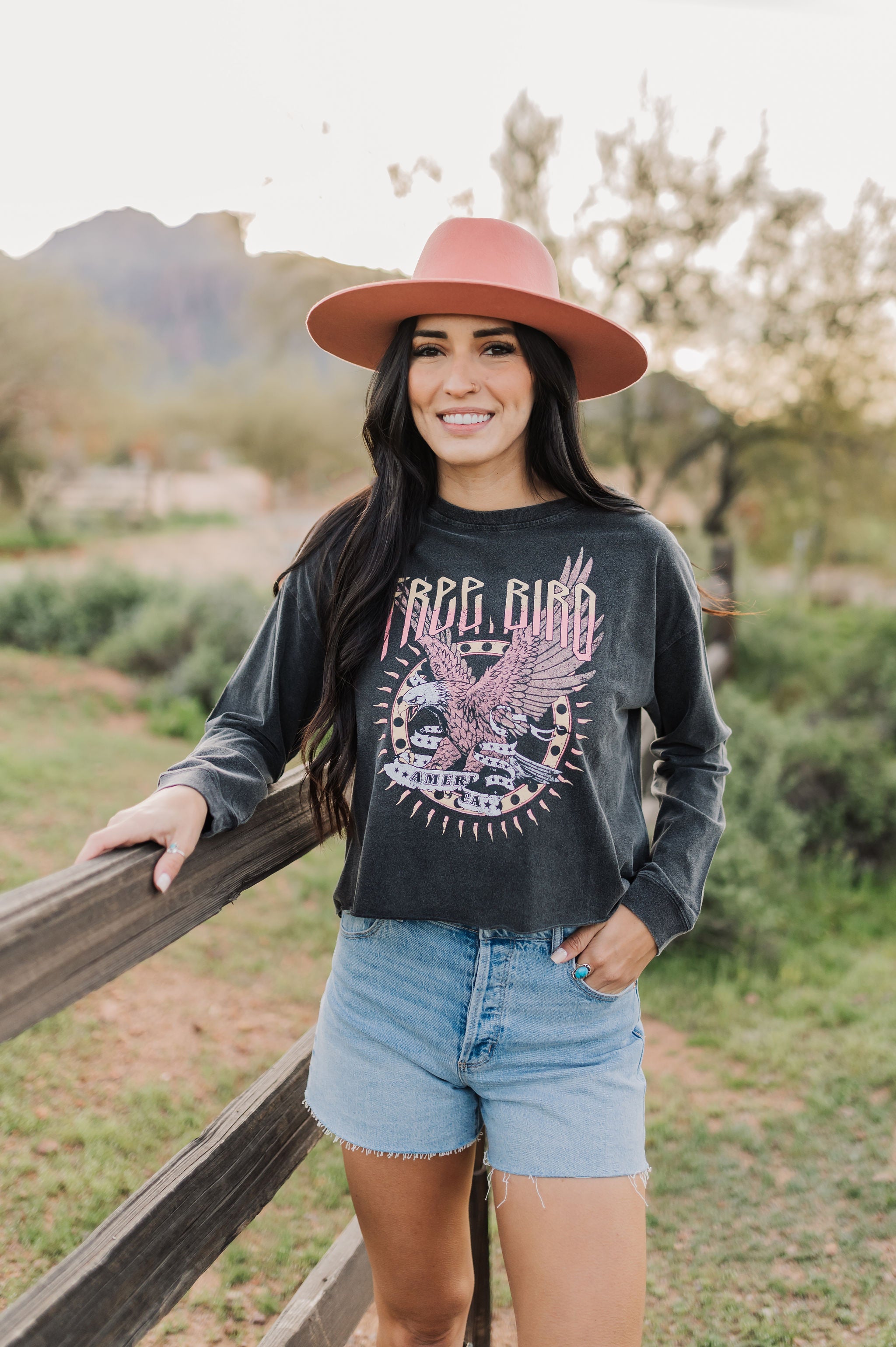 Front view of cropped Freebird Long Sleeve Graphic Tee with distressed graphic and raw hem. 