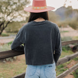 Rear view of cropped Freebird Long Sleeve Graphic Tee with raw hem. 