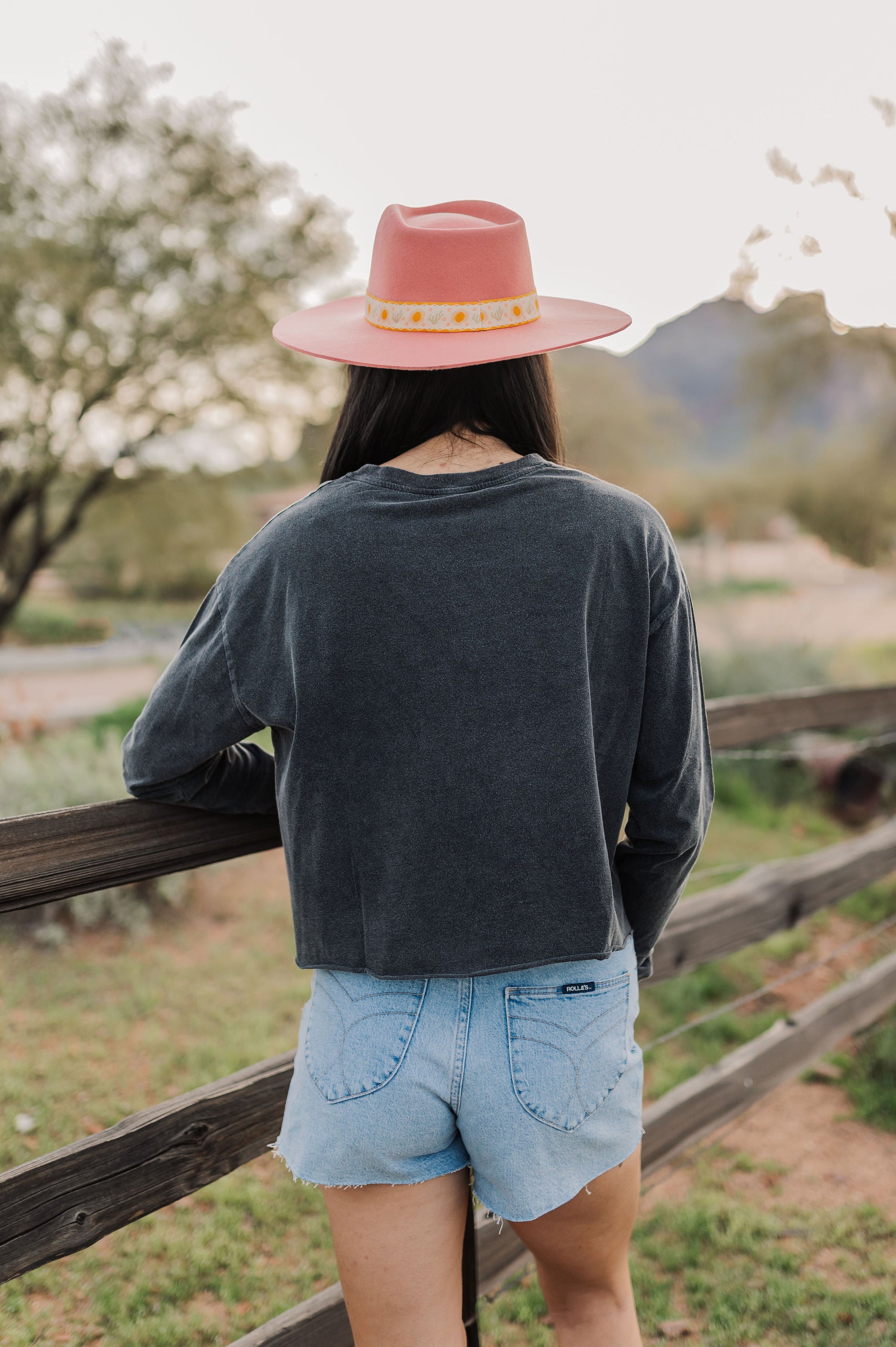 Rear view of cropped Freebird Long Sleeve Graphic Tee with raw hem. 