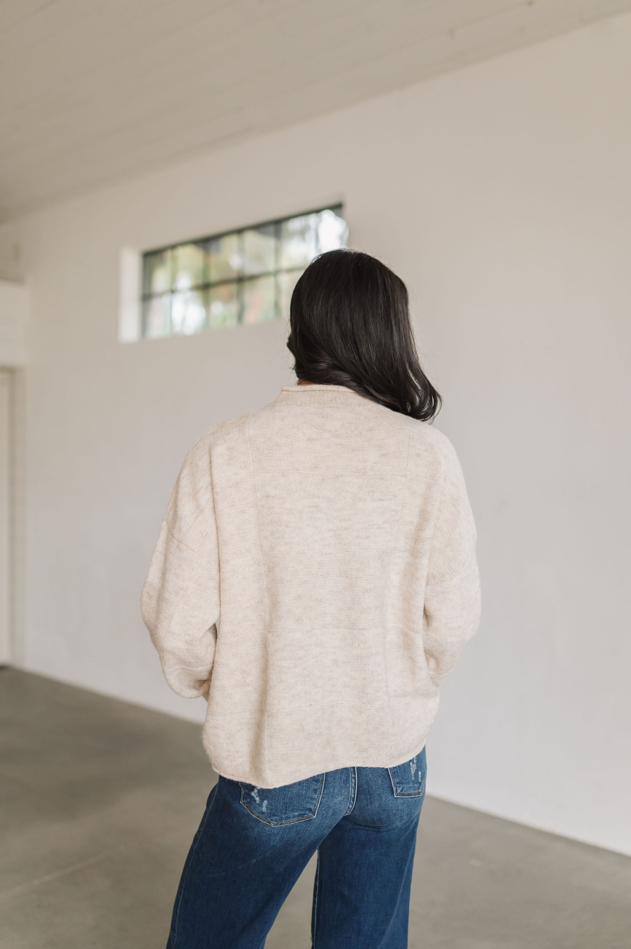 Rear view of natural Ryleigh Sweater with rolled mock neck.