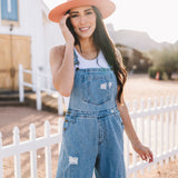 Close up front view of Clementine Wide Leg Distressed Denim Overalls with front and side pockets. 