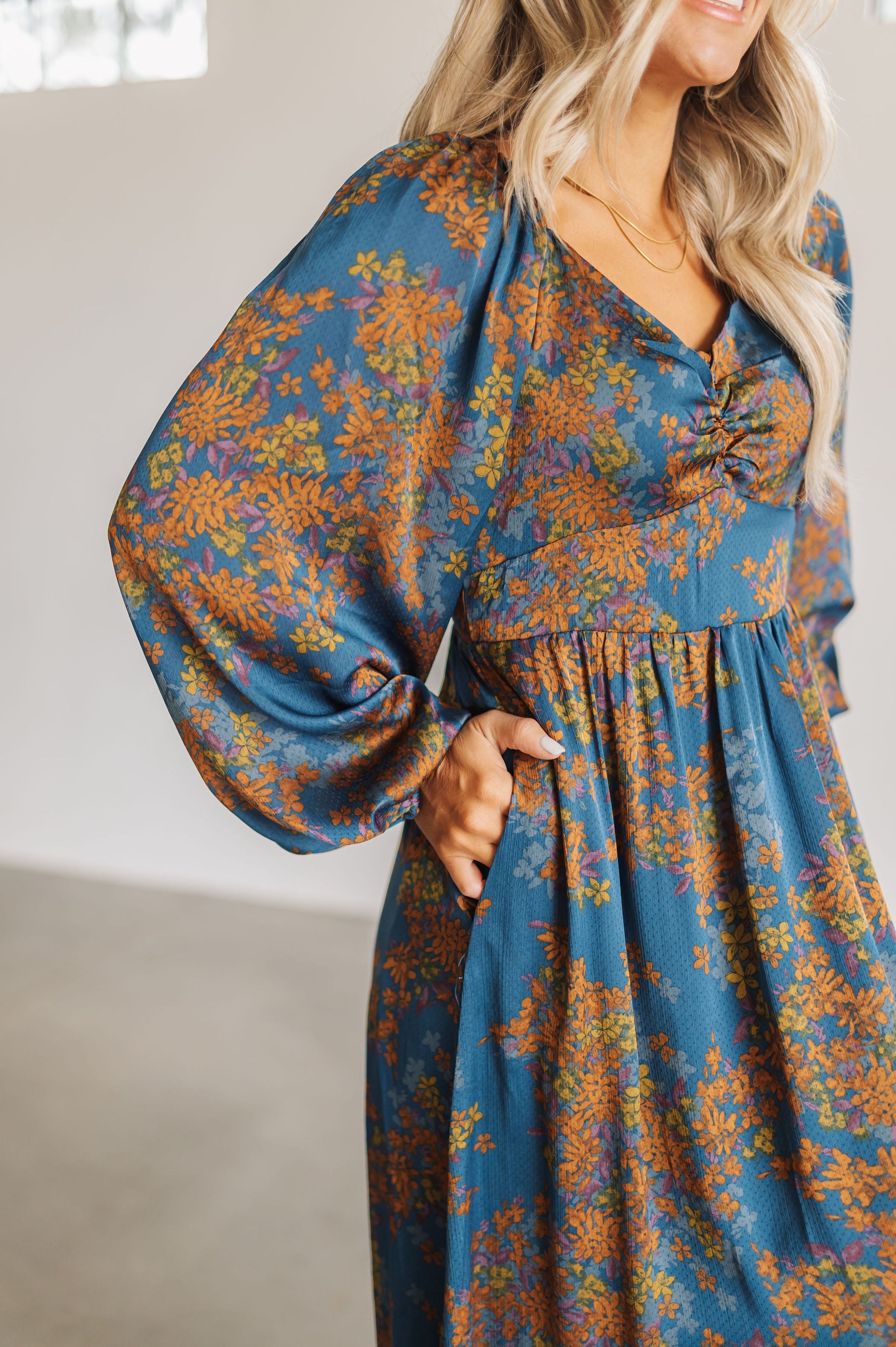 Close up front view of Sweetheart Long Sleeve Maxi Dress with floral design, puff sleeves, and pockets.
