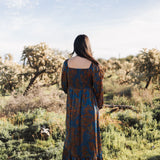 Side view of Sweetheart Long Sleeve Maxi Dress with floral design, shirred back, and ruffled hem.