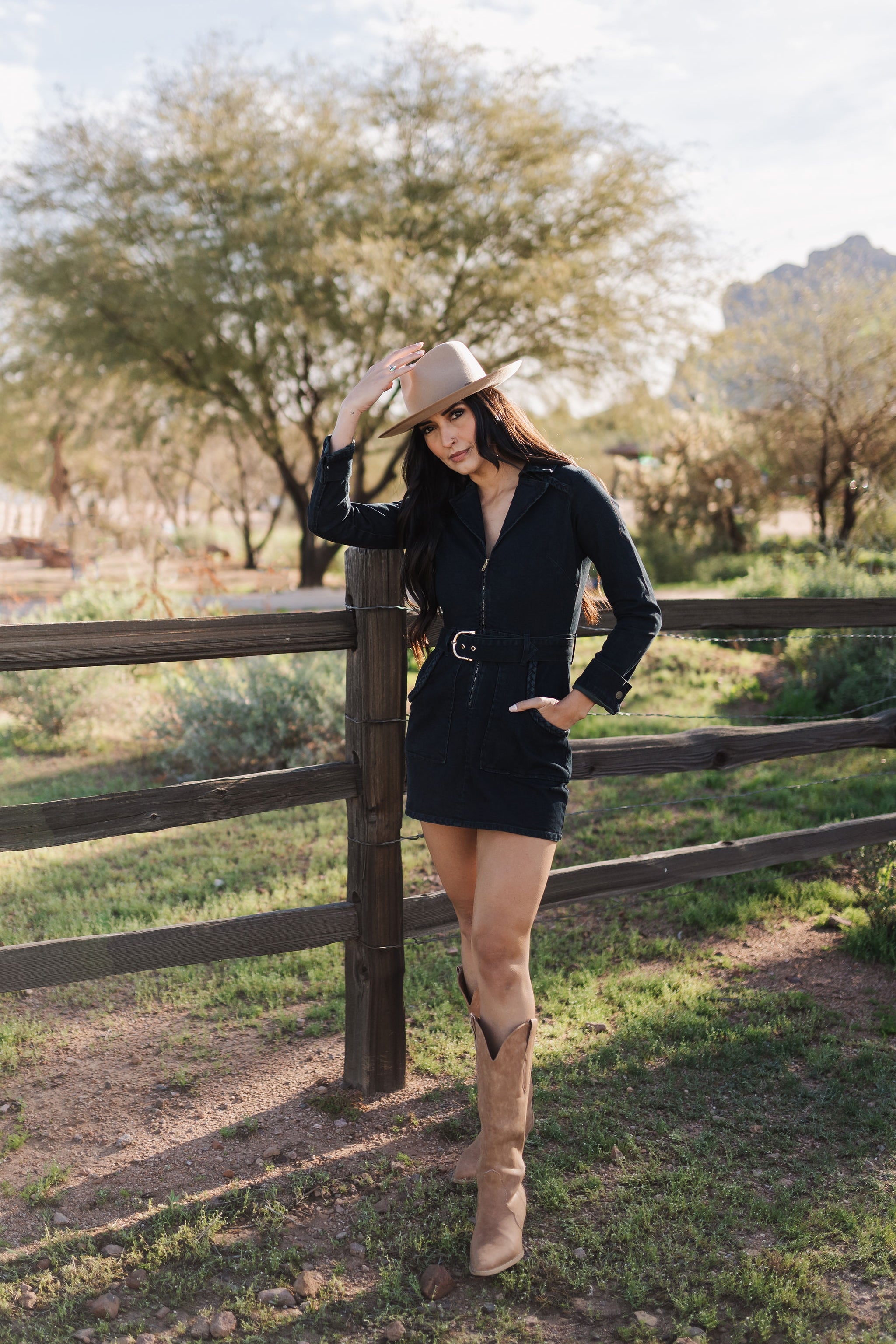 Front angled view of Outlaw Long Sleeve Dress in dark denim with zippered closure, belt, large pockets, and collared neck. 