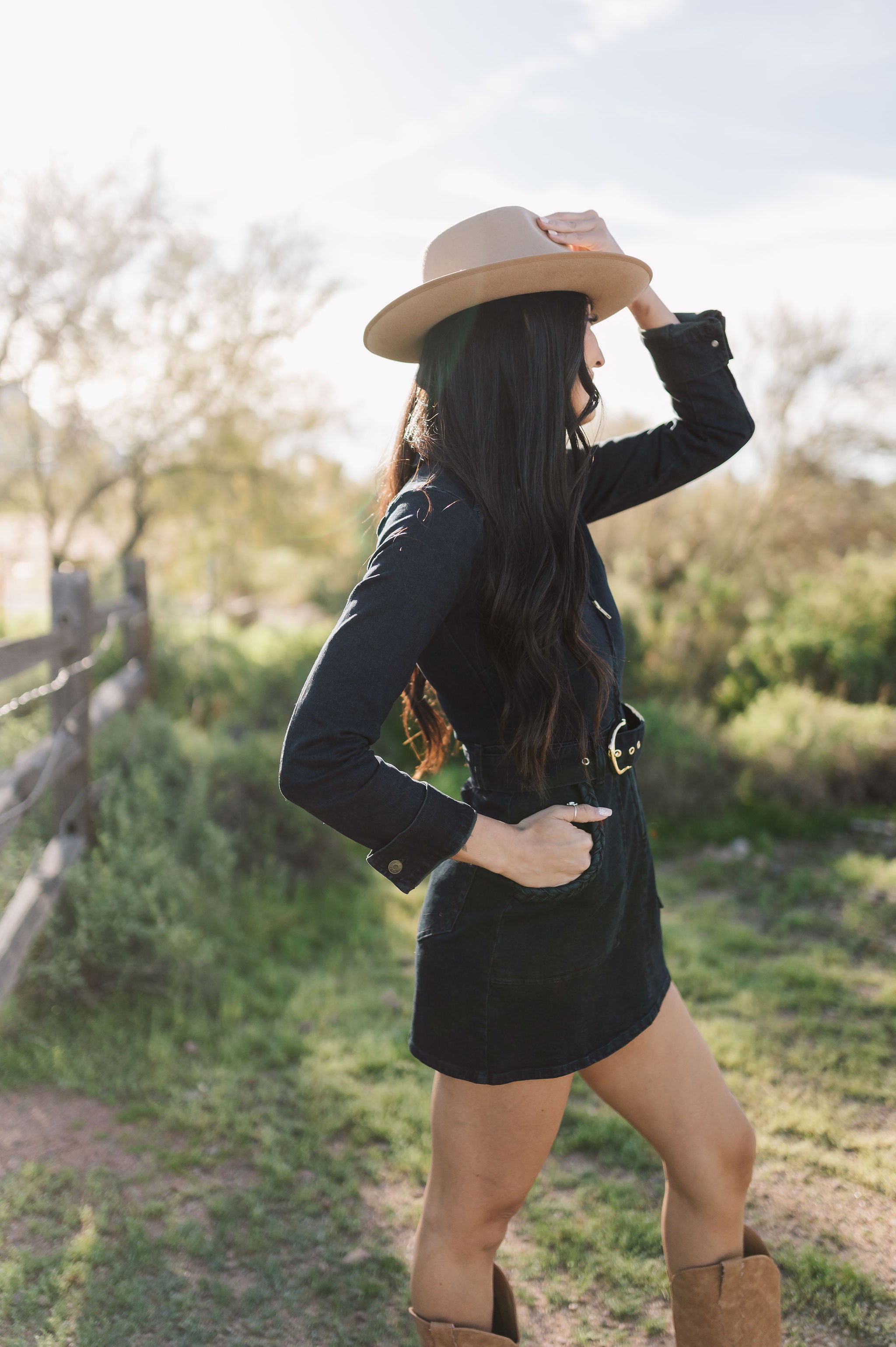 Side view of Outlaw Long Sleeve Dress in dark denim with zippered closure, belt, and large pockets.