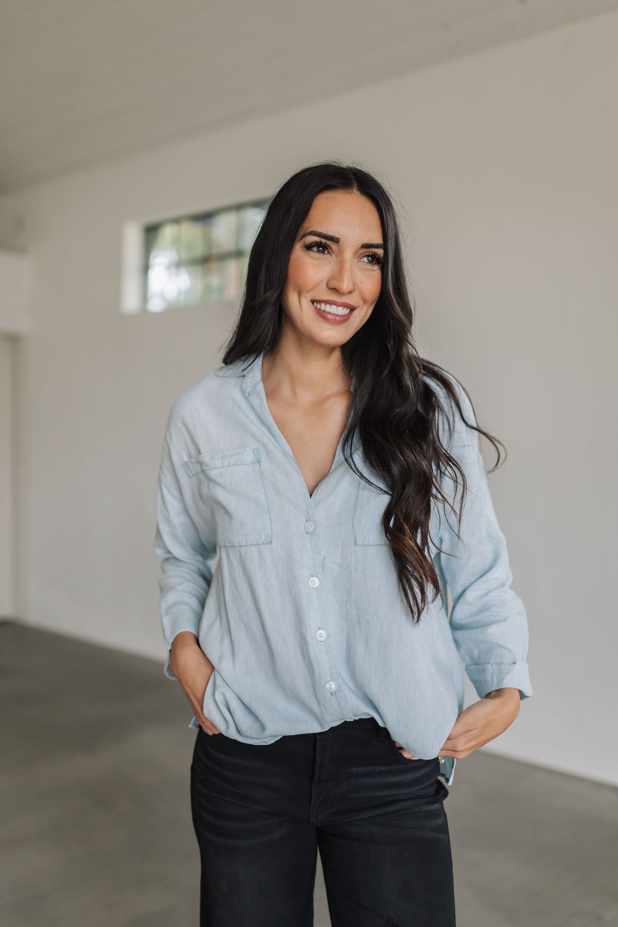 Front view of light chambray Weekday Button Up with oversized front pockets.