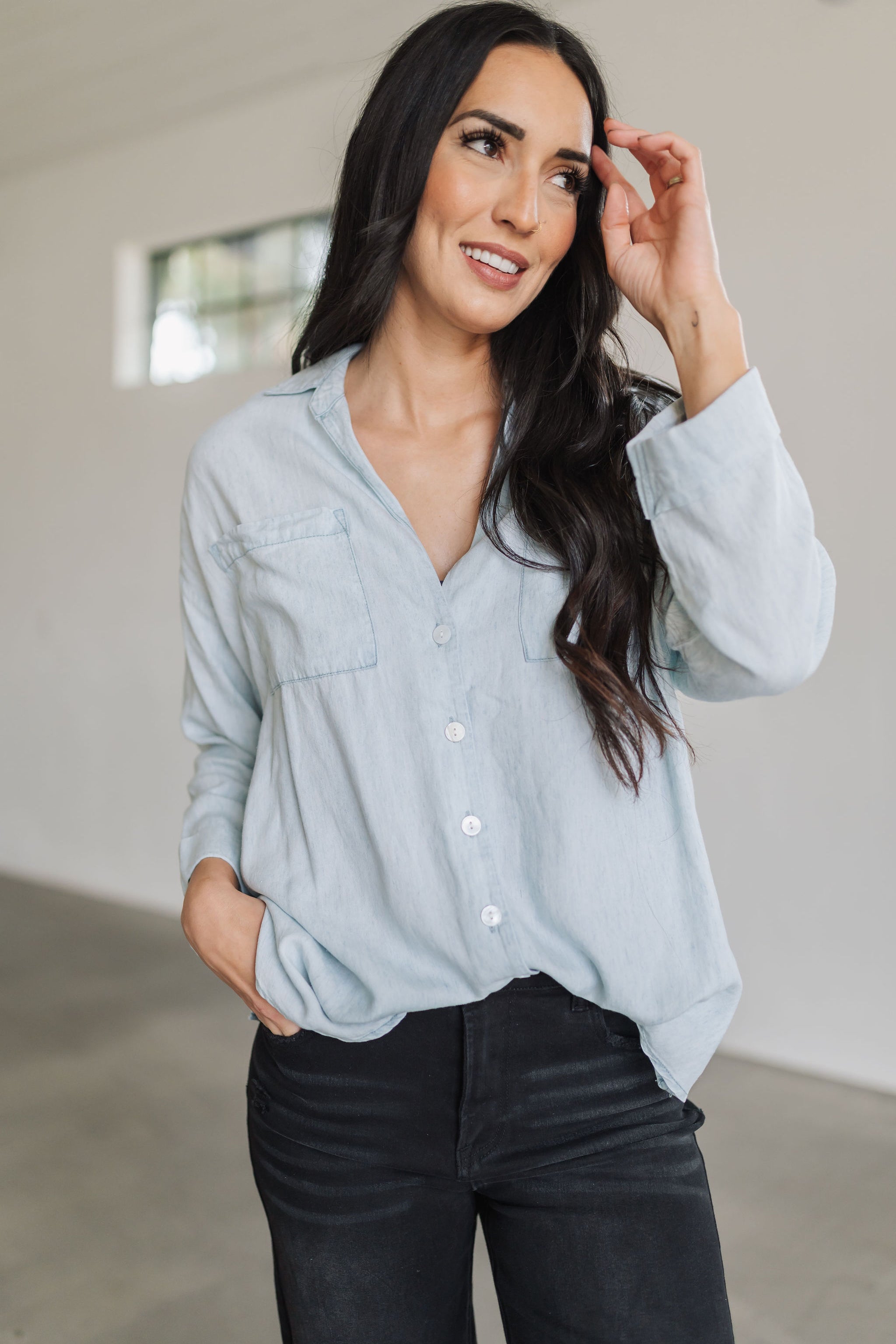 Front view of light chambray Weekday Button Up with oversized front pockets.