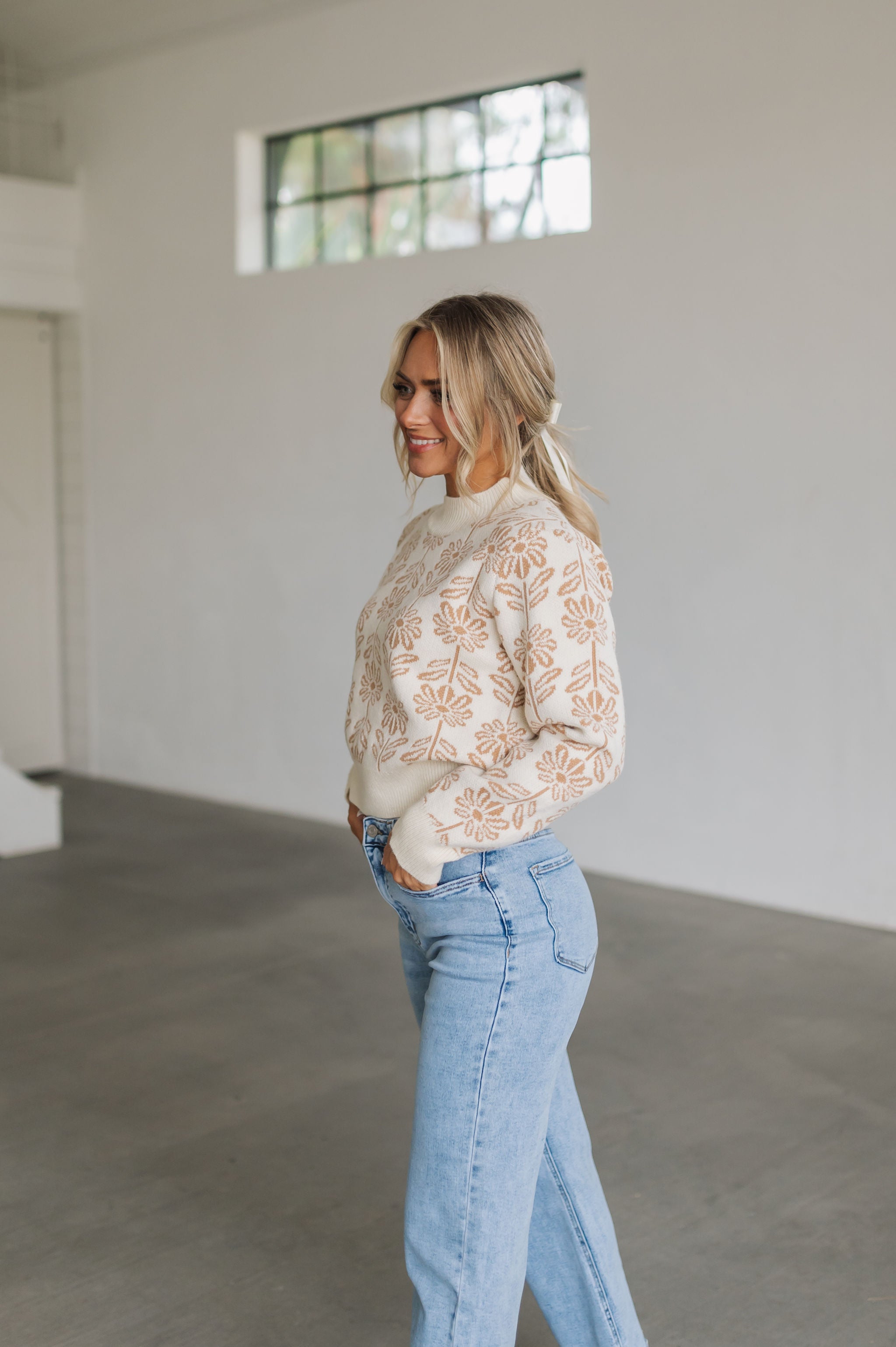 Side view of Magnolia Knit Sweater with ribbed mock neck, hem, and cuffs, and allover floral pattern. 