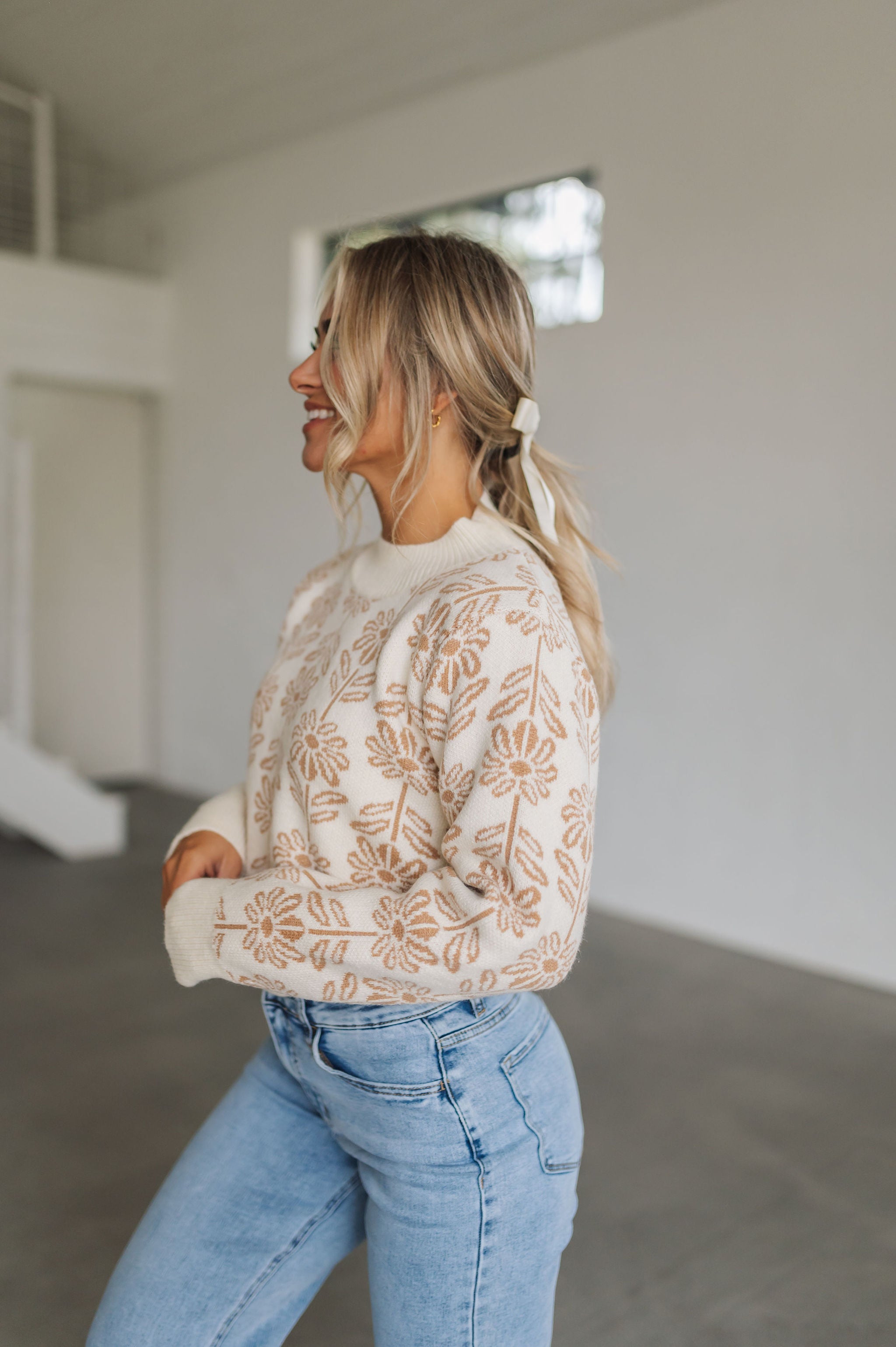 Side view of Magnolia Knit Sweater with ribbed mock neck, hem, and cuffs, and allover floral pattern. 