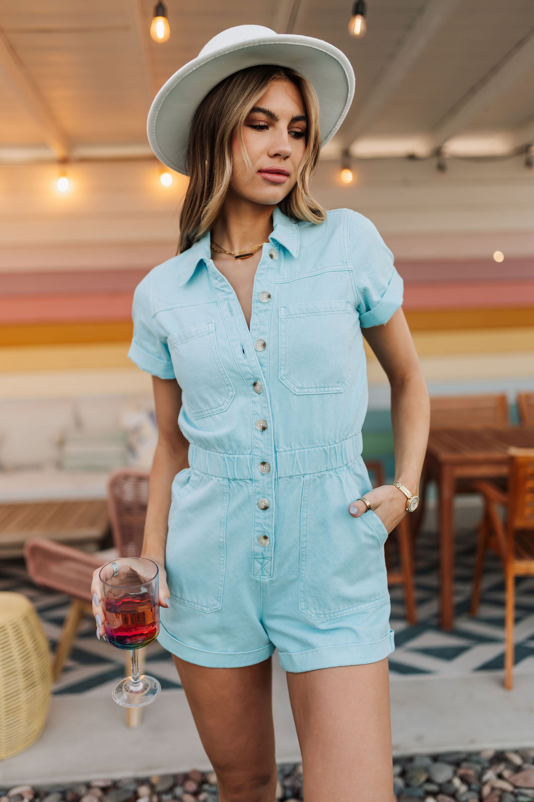 Front view of button up Cannon Romper with elastic waistband, side seam pockets,  and cuffed sleeves and hem.