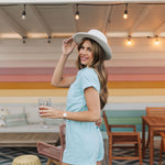 Side view of Cannon Romper with elastic waistband, cuffed sleeves and hem, and back pockets.a