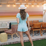 Rear view of Cannon Romper with elastic waistband, back pockets, and cuffed sleeves and hem.