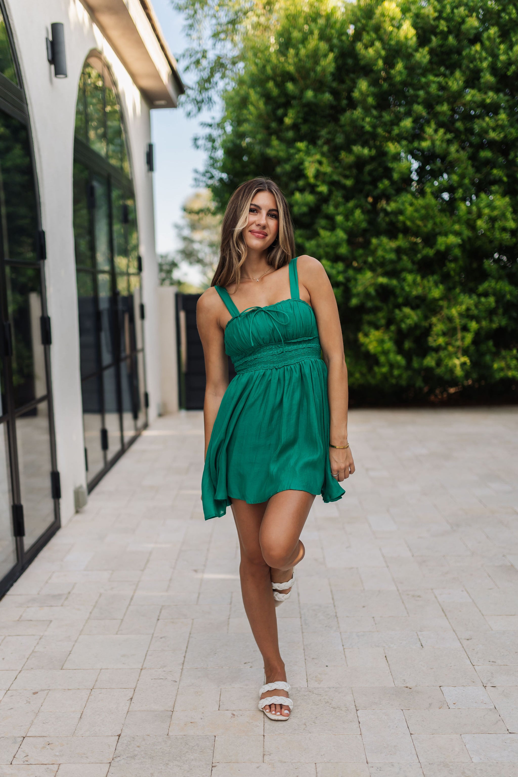 Front view of Emerald Oasis Lace Trimmed Mini Dress with adjustable thin straps, ruched top, and lace detail. 