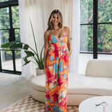 Front view of Golden Hour Jumpsuit in bright water color print, thin straps, bustier top, and wide legs. 