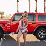 Angled front view of Trude Romper with red, white, and blue stripes.  