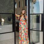 Front view of  Isle Glow Maxi Dress in allover bright floral print with short puff sleeves, sweetheart neckline, and ruffle hem. 