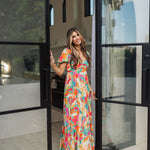 Front view of  Isle Glow Maxi Dress in allover bright floral print with short puff sleeves, sweetheart neckline, and ruffle hem. 