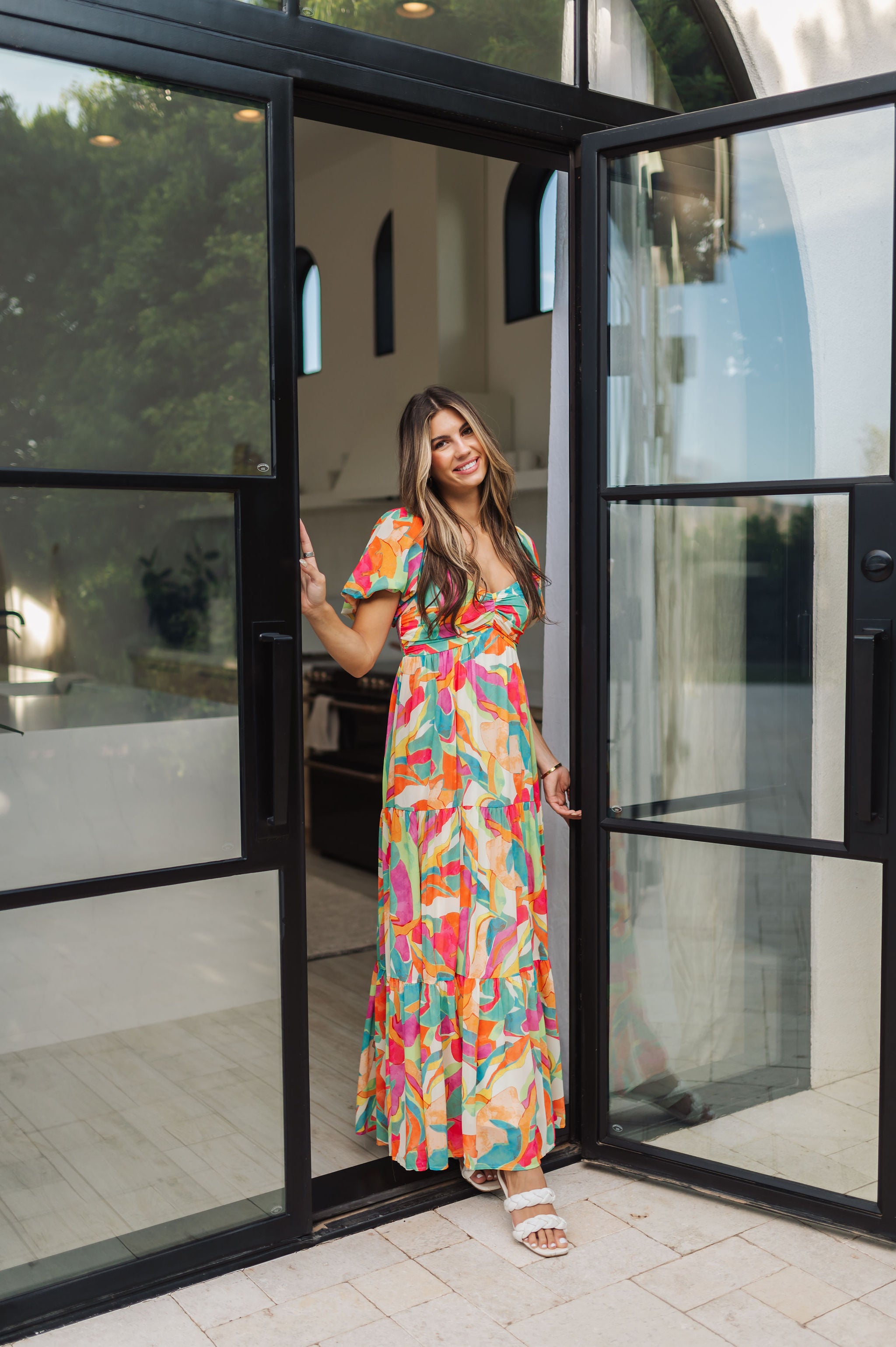 Front view of  Isle Glow Maxi Dress in allover bright floral print with short puff sleeves, sweetheart neckline, and ruffle hem. 