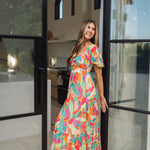 Side view of  Isle Glow Maxi Dress in allover bright floral print with short puff sleeves, sweetheart neckline, and ruffle hem. 