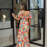 Rear view of  Isle Glow Maxi Dress in allover bright floral print with short puff  sleeves, smocked back, and ruffle hem. 