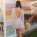 Rear view of white crochet Castaway Tunic with fringe hem, open back, and tie at neck.