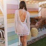 Rear view of white crochet Castaway Tunic with fringe hem, open back, and tie at neck.
