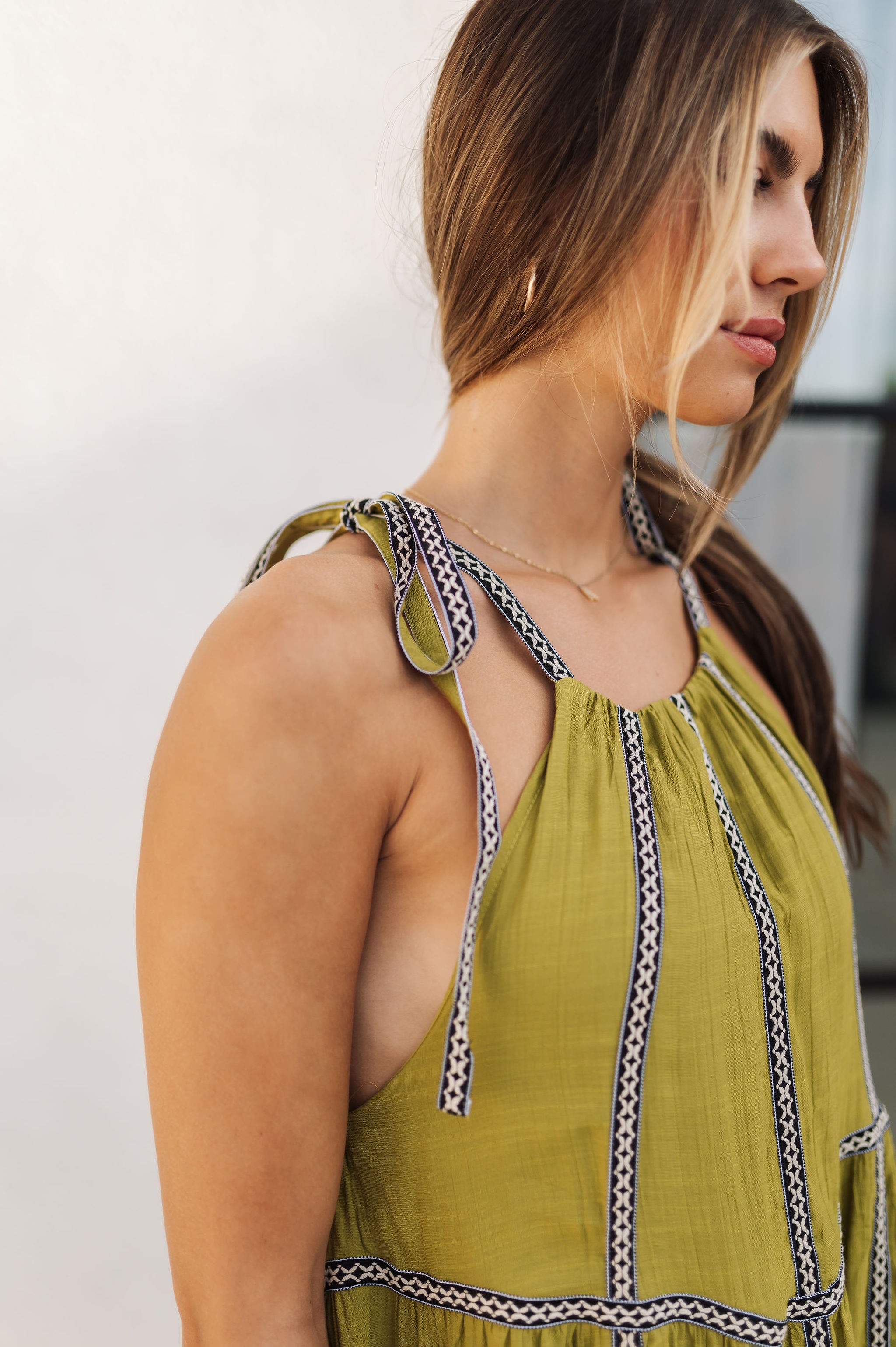 Up close side view of Palm Skies Tiered Maxi Dress in green with tiered and blocking details and self tie shoulder straps. 